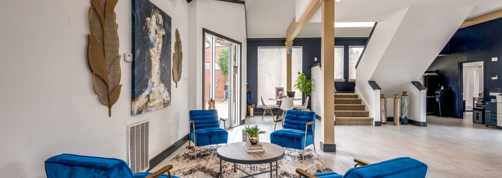 the living room features blue chairs and a large painting at The  Hathaway at Willow Bend