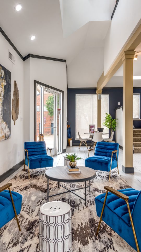 the living room features blue chairs and a large painting at The  Hathaway at Willow Bend